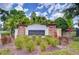 Community entrance with a brick sign reading 'Hunters Lake', surrounded by lush landscaping and trees at 1134 Tracey Ann Loop, Seffner, FL 33584