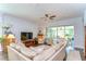 Cozy living room featuring plush seating, a ceiling fan, and a view of the screened-in patio at 1134 Tracey Ann Loop, Seffner, FL 33584