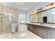 This main bathroom features double sinks, granite countertops, a shower, and a soaking tub at 1134 Tracey Ann Loop, Seffner, FL 33584