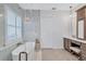 Modern bathroom with soaking tub, decorative lighting, double vanity and herringbone flooring at 11624 Bristol Chase Dr, Tampa, FL 33626