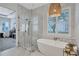 This bathroom features a soaking tub, stand up shower with glass door, and decorative hanging light fixture at 11624 Bristol Chase Dr, Tampa, FL 33626