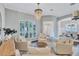 Comfortable living room featuring white chairs, a chandelier, and an arched window at 11624 Bristol Chase Dr, Tampa, FL 33626