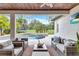 This outdoor space features comfortable seating, a decorative ceiling, and views of the pool and yard at 11624 Bristol Chase Dr, Tampa, FL 33626