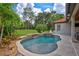 This backyard pool features a spa, waterfall, tropical landscape and lush lawn at 11624 Bristol Chase Dr, Tampa, FL 33626