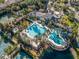 Aerial view of a community pool with a slide, cabanas, and palm trees surrounded by lush landscaping at 11624 Bristol Chase Dr, Tampa, FL 33626