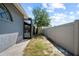 View of the backyard with a gray stucco home, walkway and white fence at 12062 Stone Crossing Cir, Tampa, FL 33635