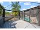 View of the screened-in pool area from the spacious, gray wooden deck with a pergola at 12062 Stone Crossing Cir, Tampa, FL 33635