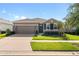 Charming single-story home featuring stone accents, a well-maintained lawn, and a two-car garage at 13227 Waterleaf Garden Cir, Riverview, FL 33579
