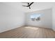 Bright bedroom with modern ceiling fan, wood-look floors and large window overlooking neighborhood at 13227 Waterleaf Garden Cir, Riverview, FL 33579