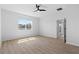Spacious bedroom featuring wood-look flooring, a ceiling fan, and a large window with abundant natural light at 13227 Waterleaf Garden Cir, Riverview, FL 33579