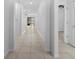 Long hallway with light tile, leading to other rooms in the house at 13227 Waterleaf Garden Cir, Riverview, FL 33579