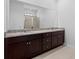 Bathroom featuring double vanity with dark wood cabinets, granite countertop, and large mirror at 13227 Waterleaf Garden Cir, Riverview, FL 33579