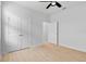 A clean bedroom showcases double doors, a ceiling fan, wood-look floors and a walk-in closet at 13227 Waterleaf Garden Cir, Riverview, FL 33579