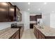 Stylish kitchen with dark wood cabinets, granite countertops, and stainless steel appliances at 13227 Waterleaf Garden Cir, Riverview, FL 33579