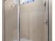 Tiled shower featuring a glass enclosure, built-in bench, and convenient toiletry niche at 13227 Waterleaf Garden Cir, Riverview, FL 33579