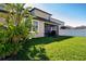 A well-maintained backyard featuring lush green grass, a screened-in lanai, and a white privacy fence at 13651 Ashlar Slate Pl, Riverview, FL 33579