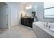 Bright bathroom featuring a soaking tub, and a double vanity with granite counters at 13651 Ashlar Slate Pl, Riverview, FL 33579