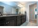 Bright bathroom featuring double sinks, granite countertops and dark cabinets at 13651 Ashlar Slate Pl, Riverview, FL 33579