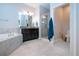 Bright bathroom featuring a soaking tub, walk-in shower, and a double vanity with granite counters at 13651 Ashlar Slate Pl, Riverview, FL 33579