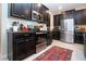 Modern kitchen with stainless steel appliances, dark cabinets, and tile flooring at 13651 Ashlar Slate Pl, Riverview, FL 33579