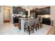Kitchen island with seating, black cabinets, and stainless steel appliances at 13651 Ashlar Slate Pl, Riverview, FL 33579