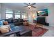 Comfortable living room with a large sectional sofa, media display, and ample natural light at 13651 Ashlar Slate Pl, Riverview, FL 33579