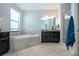Relaxing main bathroom with a soaking tub, granite countertop, and tiled floors at 13651 Ashlar Slate Pl, Riverview, FL 33579