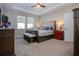 Serene main bedroom with a tray ceiling, plush carpeting, and abundant natural light at 13651 Ashlar Slate Pl, Riverview, FL 33579