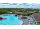 Aerial view of a lagoon style pool with lounge chairs, umbrellas and a playground in a Gathering friendly community at 13651 Ashlar Slate Pl, Riverview, FL 33579