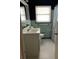 Well-lit bathroom with tiled floors, a vanity, toilet, and shower with a curtain at 1379 Pine St, Clearwater, FL 33756