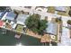 Waterfront home featuring dock, boat lift, mature trees, patio, and easy access to canals and main waterways at 13926 Helen Ave, Hudson, FL 34667