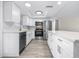 Bright kitchen features white cabinets, stainless steel appliances, and modern recessed lighting at 13926 Helen Ave, Hudson, FL 34667