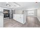Bright modern kitchen features white cabinets, stainless steel appliances, island, and gray flooring at 13926 Helen Ave, Hudson, FL 34667