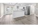 Modern eat-in kitchen with island, stainless steel appliances, bright natural light, and gray flooring at 13926 Helen Ave, Hudson, FL 34667