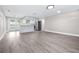 Open living area flows to the modern kitchen with an island, bright natural light, and gray flooring at 13926 Helen Ave, Hudson, FL 34667