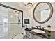 Bathroom featuring a new shower with glass doors, a decorative mirror, and an elegant vanity at 14900 Gulf Blvd # 212, Madeira Beach, FL 33708