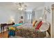 A cozy bedroom with wood floors, a colorful quilt, and a ceiling fan at 14900 Gulf Blvd # 212, Madeira Beach, FL 33708