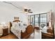 Cozy bedroom featuring wood floors, a ceiling fan, and a private balcony with stunning ocean views at 14900 Gulf Blvd # 212, Madeira Beach, FL 33708