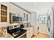 Kitchen with microwave, electric range, and washer/dryer in the corner at 14900 Gulf Blvd # 212, Madeira Beach, FL 33708