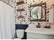 Charming bathroom featuring a modern sink, leaf wallpaper, and stylish decor at 1499 Gopher Loop, Tarpon Springs, FL 34689