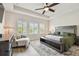 Spacious bedroom boasts natural light, a comfy chair, and a stylish wood floor at 1499 Gopher Loop, Tarpon Springs, FL 34689