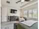 This bedroom includes a large bed, wood floors, ceiling fan, tv, and natural light at 1499 Gopher Loop, Tarpon Springs, FL 34689