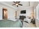 Spacious bedroom featuring wood floors, ceiling fan, tv, tray ceiling and natural light from the windows at 1499 Gopher Loop, Tarpon Springs, FL 34689