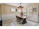 Elegant dining area with a modern table, decorative lighting, and bright windows with shutters at 1499 Gopher Loop, Tarpon Springs, FL 34689