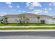 A well-maintained home exterior with lush lawn, trimmed hedges, and a clean sidewalk at 1499 Gopher Loop, Tarpon Springs, FL 34689