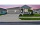 Charming home with a two-car garage, covered porch, and neatly landscaped front yard at 1499 Gopher Loop, Tarpon Springs, FL 34689