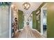 Stylish hallway with wood floors, mural, and decorative lighting leading to the bedrooms at 1499 Gopher Loop, Tarpon Springs, FL 34689