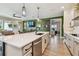 Kitchen island boasts a sink, dishwasher, and barstool seating, seamlessly connecting living spaces at 1499 Gopher Loop, Tarpon Springs, FL 34689