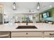 Large kitchen island with sink and seating, showcasing a sleek design and seamless flow to outdoor views at 1499 Gopher Loop, Tarpon Springs, FL 34689