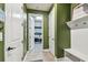 Laundry room featuring white cabinets, blue walls, and open shelving for storage and organization at 1499 Gopher Loop, Tarpon Springs, FL 34689